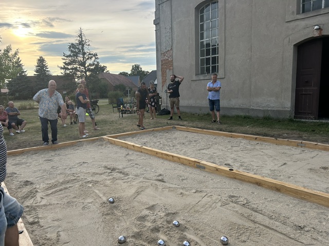 Boule-Partie im Abendlicht vor der Kirche